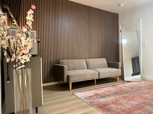 a living room with a couch and a vase with flowers at The Amy Su in San Fernando