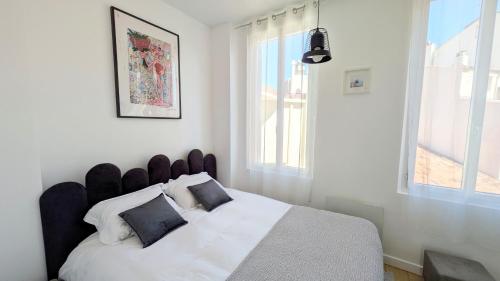 - une chambre avec un lit blanc et une tête de lit noire dans l'établissement cocooning # lumineux # Vieille ville, à Antibes