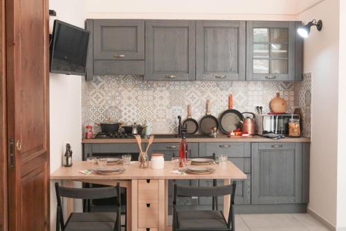 a kitchen with gray cabinets and a table with chairs at -Casa Trevisone- in Salerno