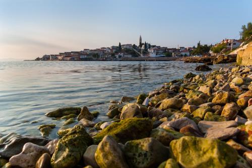 a group of rocks on the shore of the water at Penthouse Petra with hot tub in Kali
