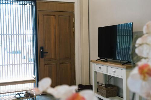una camera con televisore e porta con finestra di SuXiang - Chinatown, Bangkok a Bangkok