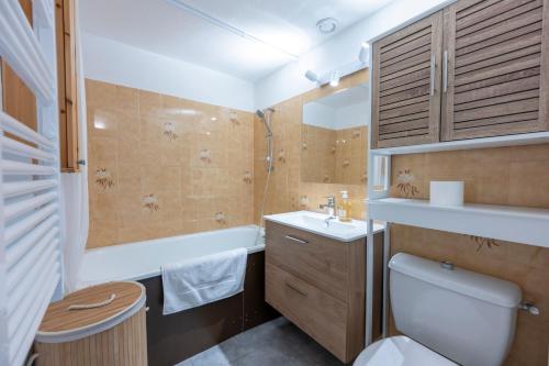 a bathroom with a toilet and a sink and a tub at Nid Paisible - Balcon - Calme - Parking in Barcelonnette