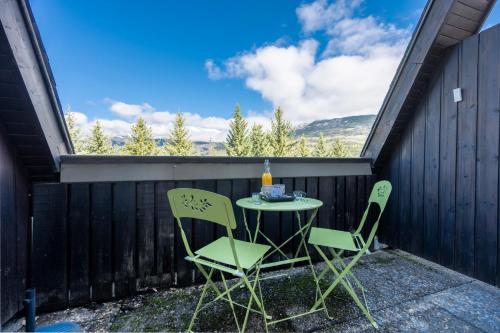 a table and two chairs on a patio with a view at Nid Paisible - Balcon - Calme - Parking in Barcelonnette
