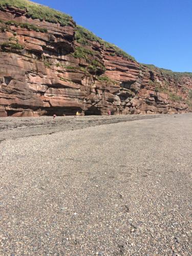a large rock wall with a mountain in the background at High House Cottage - A traditional home from home in St Bees