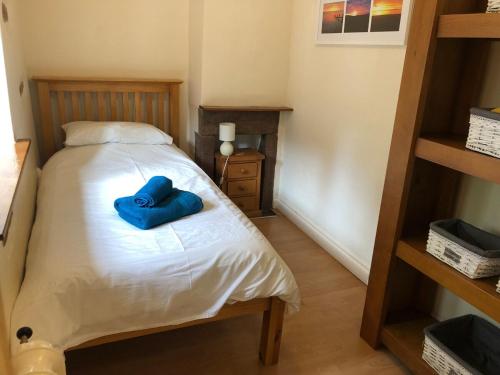 a bedroom with a bed with a blue pillow on it at High House Cottage - A traditional home from home in St Bees