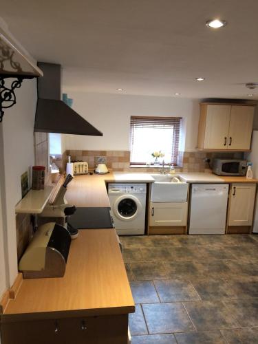 a kitchen with a sink and a stove top oven at High House Cottage - A traditional home from home in St Bees