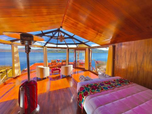 a bedroom on a boat with a bed and a table at Uros Qhantany Lodge in Puno