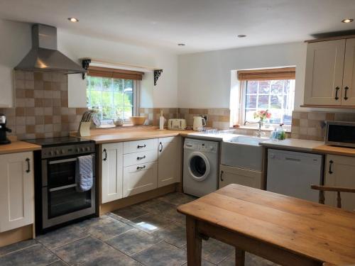 a kitchen with a sink and a washing machine at High House Cottage - A traditional home from home in St Bees