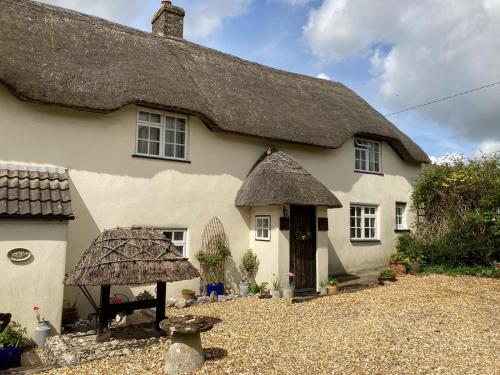 Milborne Saint AndrewにあるGuest Suite at 31 Little Englandの茅葺き屋根の大白い家