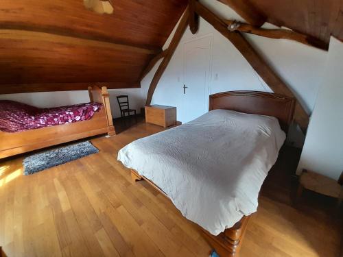 - une chambre mansardée avec un lit et du parquet dans l'établissement Maison de montagne avec vue sur Pyrenees, à Soulan