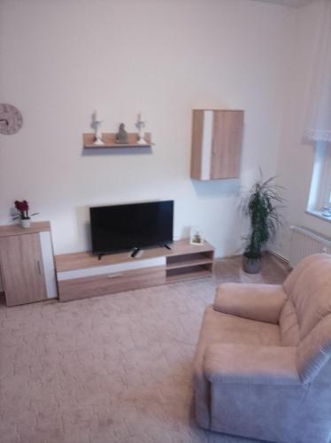 a living room with a flat screen tv and a couch at Ferienwohnung Poschmann in Bad Wilsnack