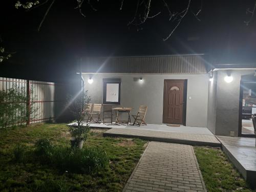 a house with a table and chairs at night at Habitat of Dreams in Makó