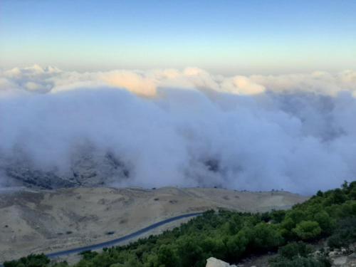 a group of clouds in the sky over a mountain at Dana Mount View the highest hotel in Jordan in Dana