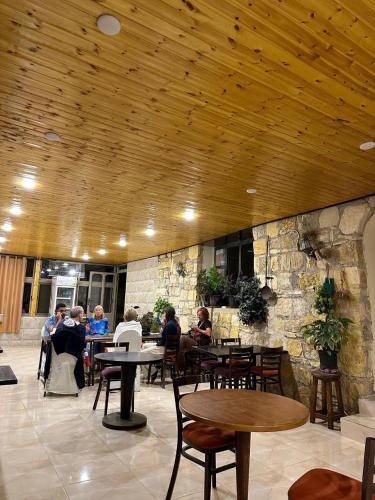 a group of people sitting at tables in a restaurant at Dana Mount View the highest hotel in Jordan in Dana