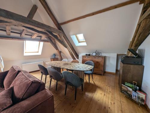 un salon avec une table et des chaises dans l'établissement Appartement comble en centre ville de Bellême, à Bellême
