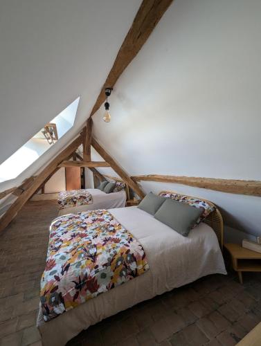une chambre avec un lit dans un grenier dans l'établissement Appartement comble en centre ville de Bellême, à Bellême