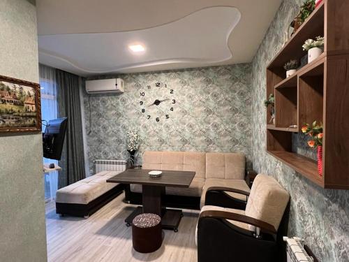 a living room with a couch and a table at Квартира у приморского парка in Batumi