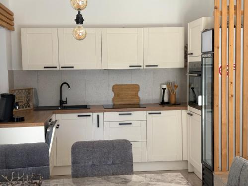 een keuken met witte kasten en een spoelbak bij The House in Medulin