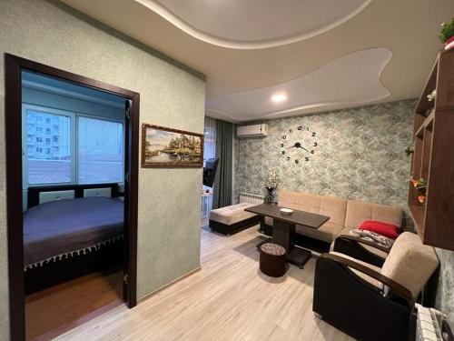 a living room with a couch and a bed at Квартира у приморского парка in Batumi