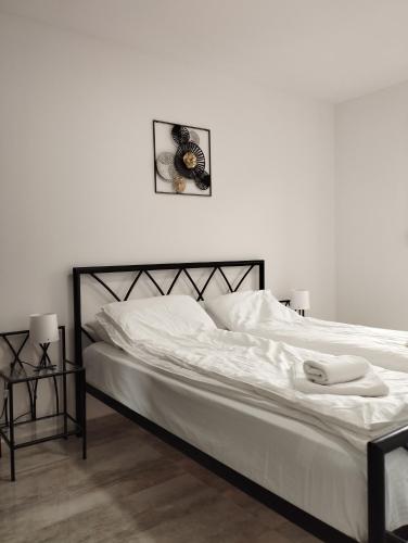 ヴェリコ・グラディシュテにあるApartman IDAの白いベッド(黒枠、白いシーツ付)