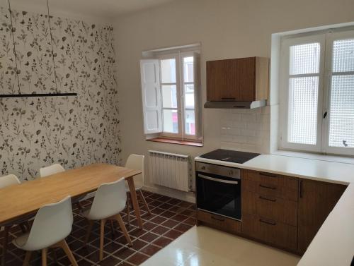 a kitchen with a table and a table and chairs at Amplio piso en casa histórica en primera planta in Sabiñánigo