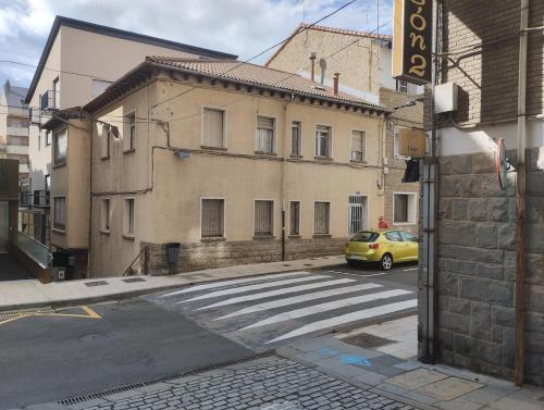 a yellow car is parked in front of a building at Amplio piso en casa histórica en primera planta in Sabiñánigo