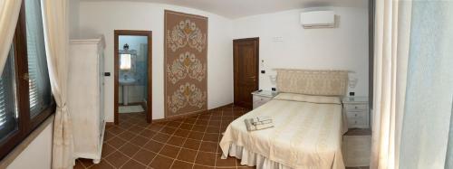 a bedroom with a bed and a tiled floor at Domo Rosada in Ottava Sassari