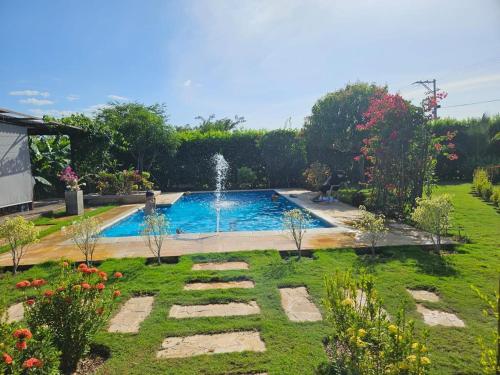 a swimming pool in a garden with a fountain at casa campo in Estación El Salto