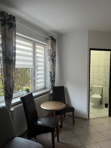 a room with a table and two chairs and a window at Willa Puchatek in Gąski