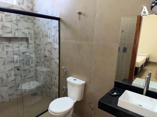 a bathroom with a toilet and a shower and a sink at Rancho paraíso l in Miguelópolis