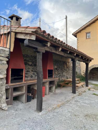 an outdoor shelter with a roof on a building at Casa Vella del Cuní in Roda del Ter