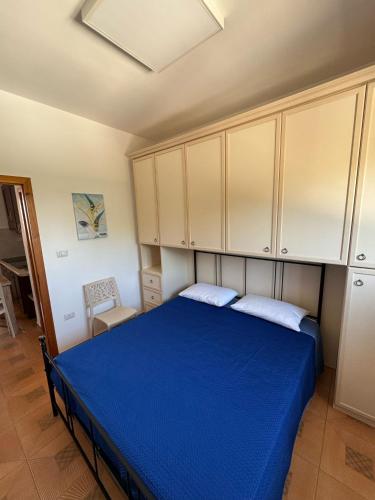 a bedroom with a blue bed and white cabinets at Casa Vacanza Chalet in Campomarino