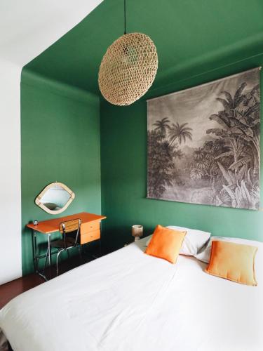- une chambre avec un mur vert, un lit et un bureau dans l'établissement Casëto Luberon, à Apt
