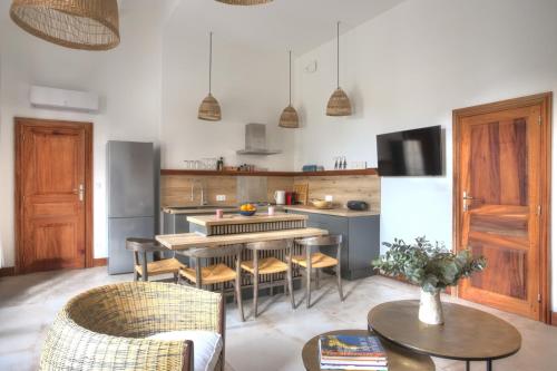 - une cuisine avec une table, des chaises et un comptoir dans l'établissement Suite côté sud avec terrasse en centre ville, à Arles