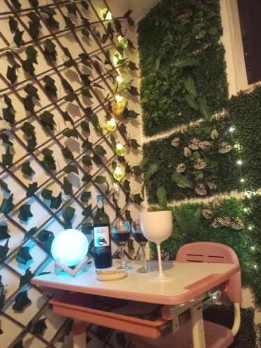 a table with wine glasses and a wall with plants at Apartamento Le petit prince in Paipa