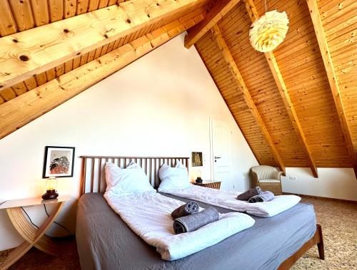 two beds in a attic bedroom with wooden ceilings at Ferienhaus an der Schlei in Kappeln