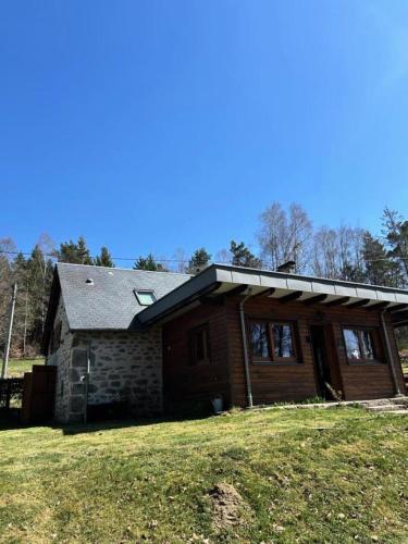 a log home with a gambrel roof on a field at Gîte de France Le fournil de paulette et guy 4 épis - Gîte de France 6 personnes MAE-0154 in Bonnefond