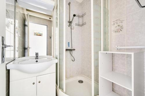 une salle de bain blanche avec un lavabo et une douche dans l'établissement Résidence Le Tourmalet - maeva Home - Studio 4 personnes - Budget MAE-3731, à La Mongie
