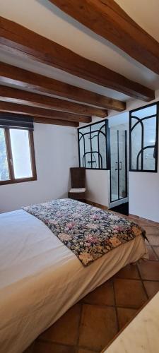 Cette chambre comprend un grand lit et des fenêtres. dans l'établissement La Ribasse en Provence, à Venelles