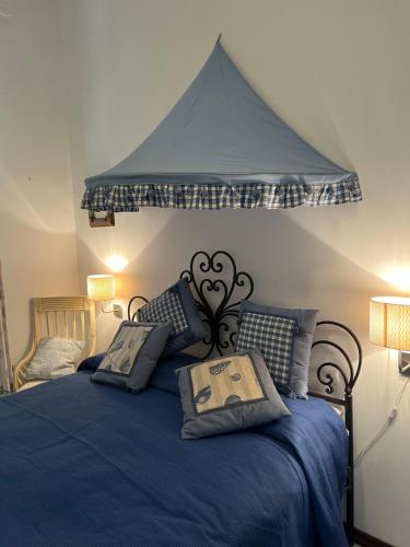 a bedroom with a blue bed with a canopy at Casa Bacot in Canneto