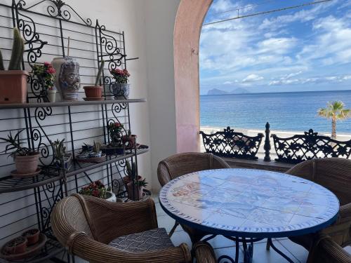 a patio with a table and chairs and the ocean at Casa Bacot in Canneto