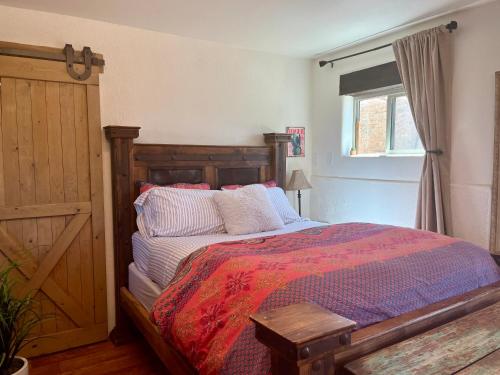 a bedroom with a bed with a wooden head board at Prickly Pear Unique Studio with bathroom built into the Granite boulders, Amazing Views, Front & back porches, Firepit,Dog friendly in Prescott