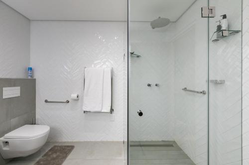 a bathroom with a toilet and a glass shower at Forest Town Getaway close to the Parks in Johannesburg