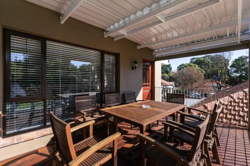 a wooden table and chairs on a patio at Forest Town Getaway close to the Parks in Johannesburg