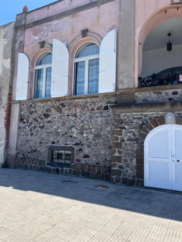 a stone building with white doors and windows at Casa Bacot in Canneto
