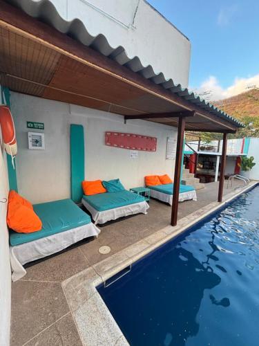 Una habitación con dos camas al lado de una piscina. en Sierraventura Hostel, en Taganga