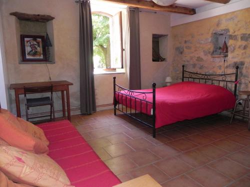 - une chambre avec un lit rouge et une fenêtre dans l'établissement Studio à Générargues, en Cévennes, proche Anduze, à Générargues