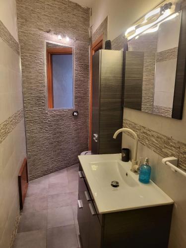 a bathroom with a white sink and a mirror at Due minuti dal mare con Balcone Vista Mare in Tropea
