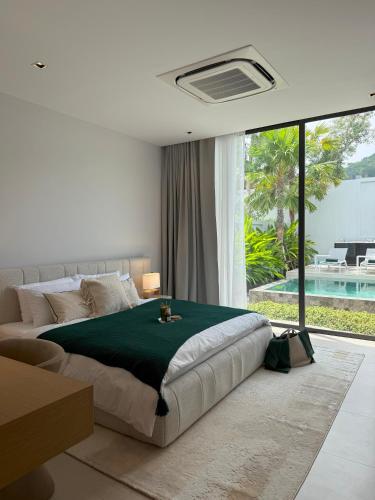 a bedroom with a large bed and a large window at Botanica Foresta B10 in Phuket