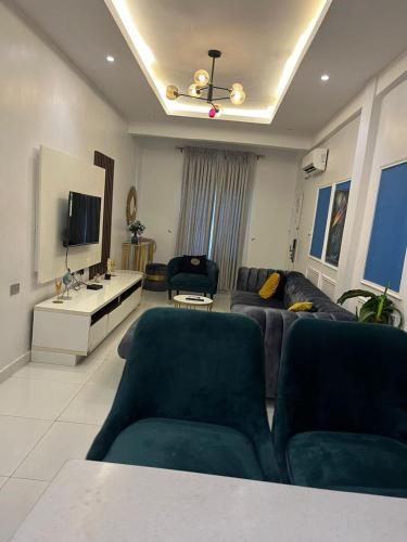 a living room with a couch and a tv at 2 Bedroom Luxury Apt with Pool & Jacuzzi in Maiyegun